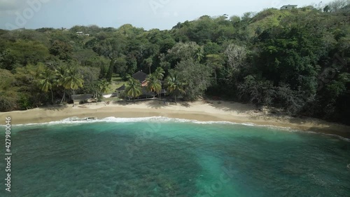 Waves crashing the shoreline of this amazing crystal clear water beach Arnos Vale located on the Caribbean island of Tobago photo