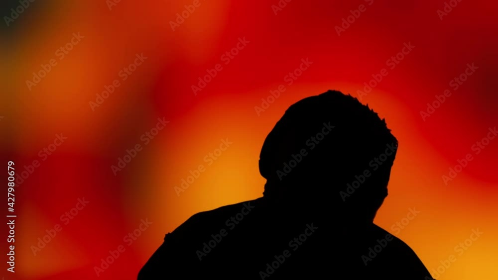 The silhouette of a man wearing headphones, happily dancing to the music, over intense defocused fire tongues.
The silhouette of a man wearing headphones, happily dancing to the music, over intense defocused fire tongues.