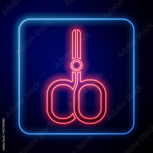 Glowing neon Nail scissors cuticle cut beauty salon icon isolated on blue background. Cosmetic scissors for manicure. Vector