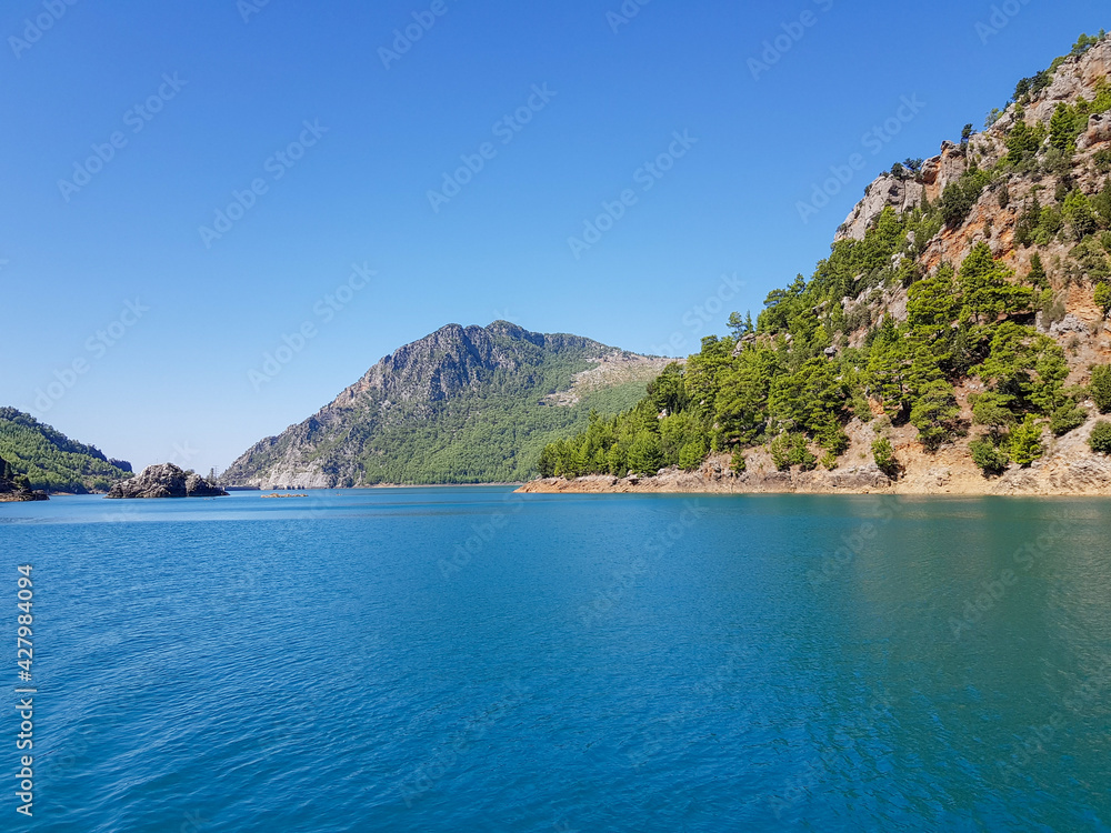 Seascape against the backdrop of mountains on a cloudless sunny day.