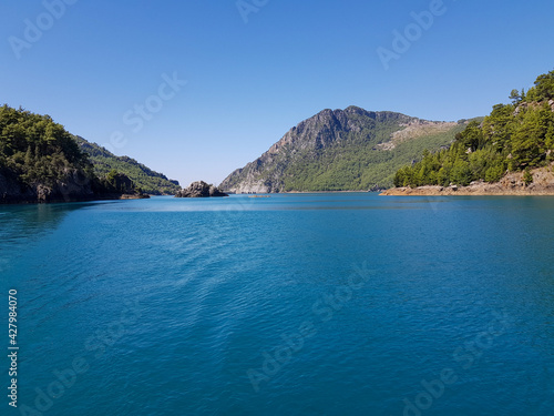 Seascape against the backdrop of mountains on a cloudless sunny day. © Сергей Лазареско
