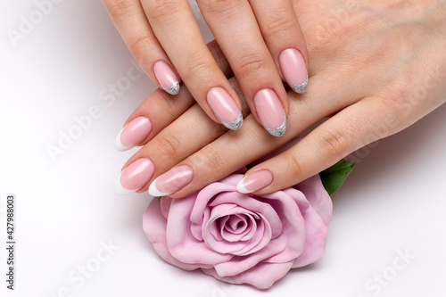 Wedding French white  silver manicure on long oval nails with a pink rose in hands