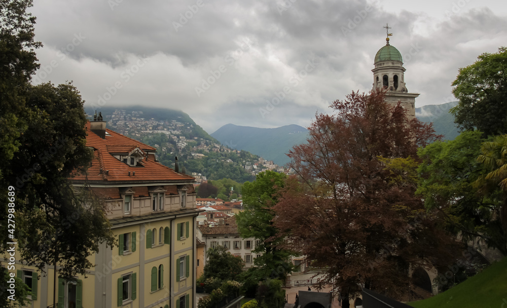 photo of the architecture in the city of lugano , switzerland, under a cloudy sky