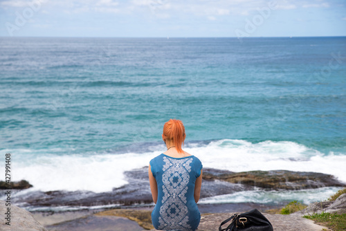 a woman sitting facing the bay in sydnay australia