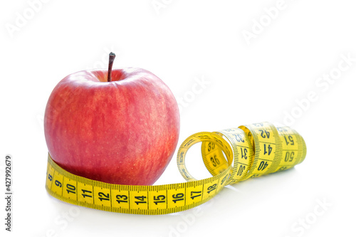Red apple with measuring tape isolated on white background. Healthy lifestyle, diet concept. Close-up