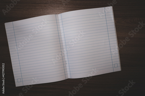 Line notebook on a dark wooden table. Free space for text