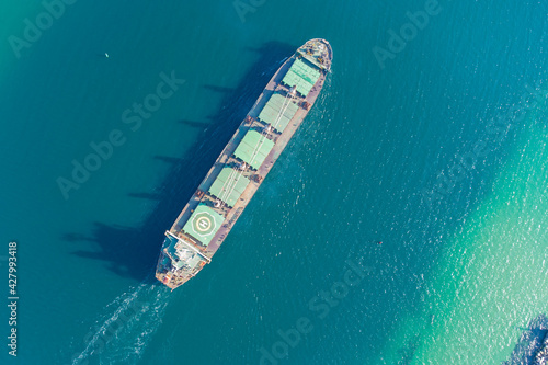 The dry cargo vessel enters the port with the help of tugs. Photo from a helicopter. Bird's-eye view. © Виктор Кеталь
