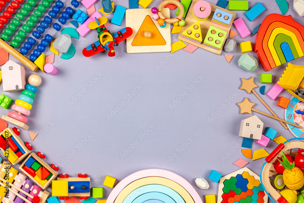Baby kids toys frame. Colorful educational wooden plastic and fluffy toys for children on gray background. Top view, flat lay Baby kids toys frame. Colorful educational wooden plastic and fluffy toys for children on gray background. Top view, flat lay