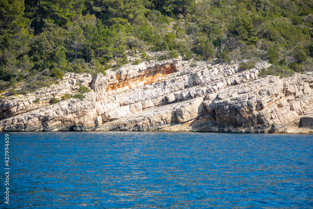 View from water of rocky shore of island in Croatia