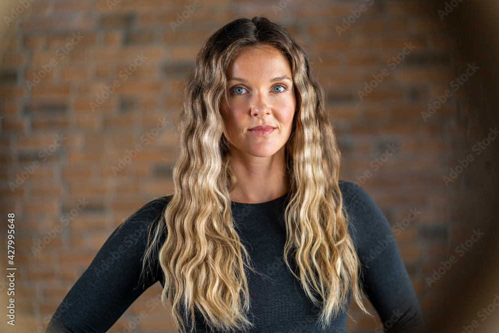Fototapeta premium Beautiful young woman lifting weight. Strong empowered determined and confident powerful women concept