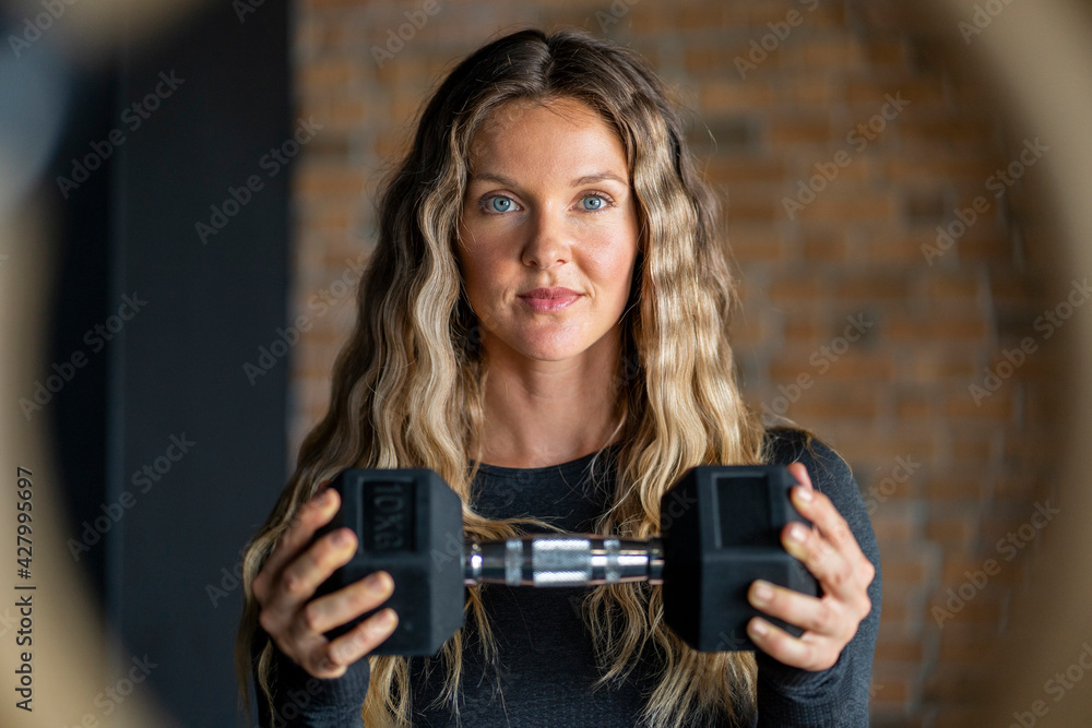Beautiful young woman lifting weight. Strong empowered determined and confident powerful women concept Beautiful young woman lifting weight. Strong empowered determined and confident powerful women concept