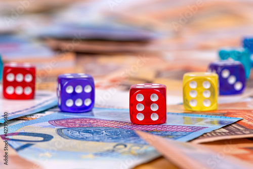 multicolored dice close-up on a background of euro banknotes, business opportunity and risk concept