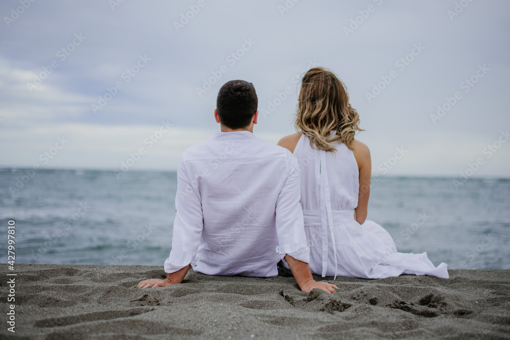 couple on the beach on their wedding day bride and groom watching sunset