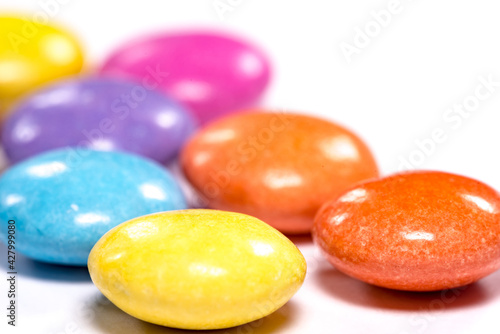 Colorful dragees, close-up on a white background. Chocolate candies in a colored shell, glaze.
