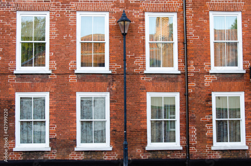 Detail of a building with street lamp and typical English windows.