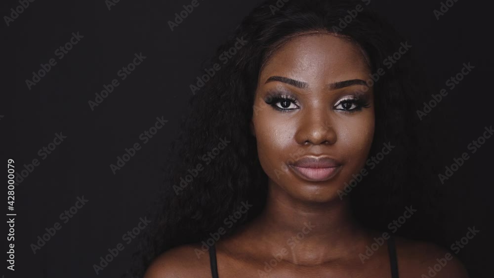 Young african female looking at camera on dark background, women's rights, abuse Young african female looking at camera on dark background, women's rights, abuse