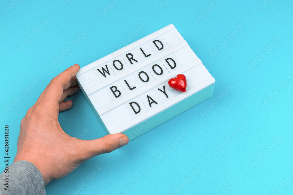 World blood donor day background, man hold lightbox with message, text and inscription World blood donor day background, man hold lightbox with message, text and inscription