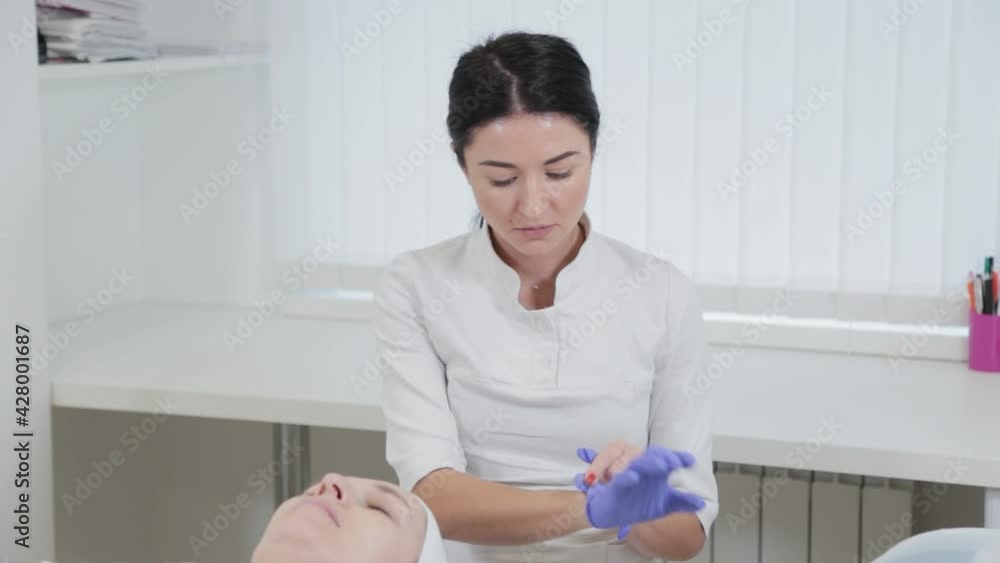 Woman beautician putting on rubber gloves. Woman beautician putting on rubber gloves.