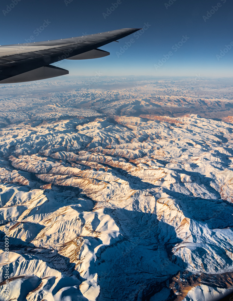 Aerial View from an Airplane. Flying above Beautiful Land at Sunrise.