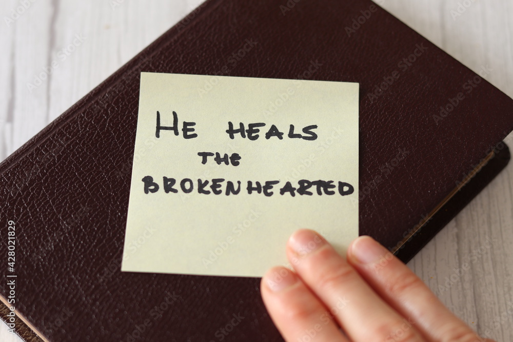 God Jesus Christ our Healer and Deliverer loves us and heals our wounds, forgives our sins. Bible promise verse from Psalms book Old Testament. The handwritten message of hope and truth. God Jesus Christ our Healer and Deliverer loves us and heals our wounds, forgives our sins. Bible promise verse from Psalms book Old Testament. The handwritten message of hope and truth.