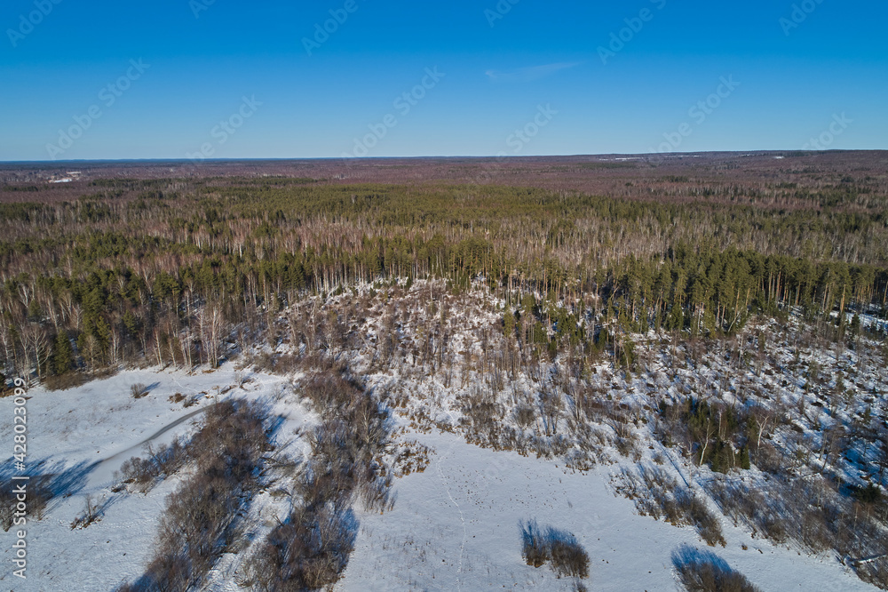 Beautiful Sunny landscape with forest, snow and frozen river. Aerial photography from a drone Beautiful Sunny landscape with forest, snow and frozen river. Aerial photography from a drone