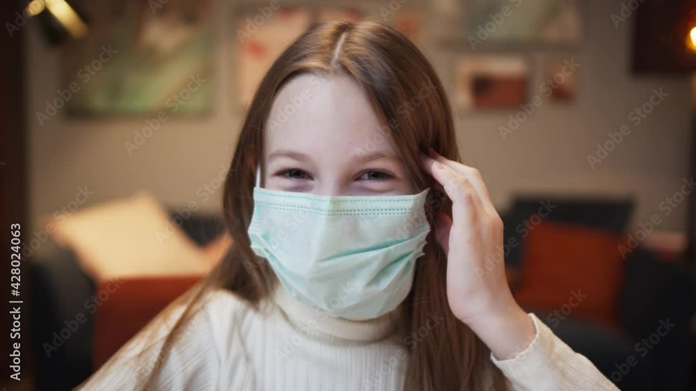 Portrait of pretty girl with long red hair, kid wearing a mask looking in camera, rolling her eyes, grimacing, laughing on video conference call. Remote home video lesson. Portrait of pretty girl with long red hair, kid wearing a mask looking in camera, rolling her eyes, grimacing, laughing on video conference call. Remote home video lesson.