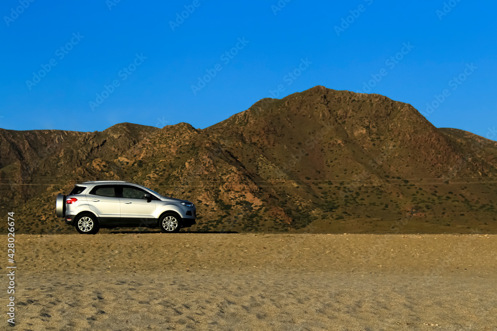 Suv car parked in Mountainous landscape in the desert