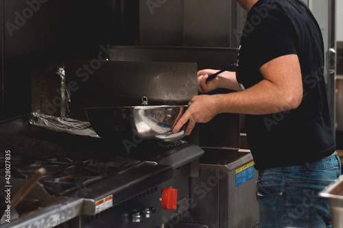 Restaurant employee using frier in a kitchen