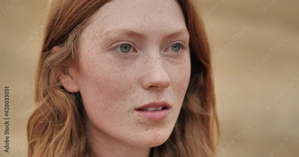 Close Up Portrait of Mysterious Ginger young Woman opening her blue Eyes, breathing fresh Air. Wind blowing airy Red Hair. Attractive girl with nice Freckles. Natural Beauty. People. Liberty. Close Up Portrait of Mysterious Ginger young Woman opening her blue Eyes, breathing fresh Air. Wind blowing airy Red Hair. Attractive girl with nice Freckles. Natural Beauty. People. Liberty.