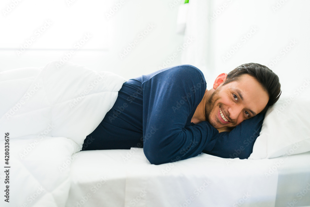 Attractive guy resting in bed during a leisure morning Attractive guy resting in bed during a leisure morning