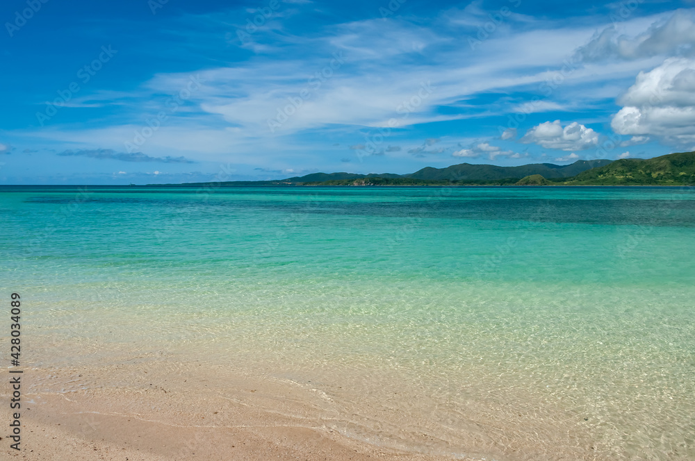 Incredible sea, extremely transparent emerald green, some waves, Iriomote island in the background on a sunny day in a paradisiacal tourist spot at Kohama island. Incredible sea, extremely transparent emerald green, some waves, Iriomote island in the background on a sunny day in a paradisiacal tourist spot at Kohama island.