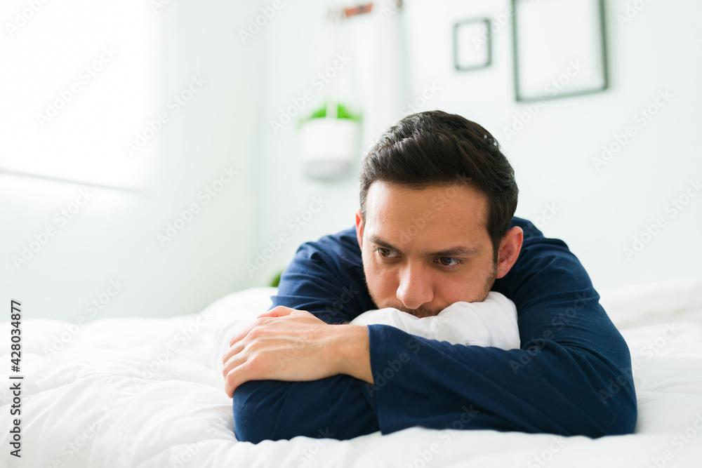 Reflexive man in bed thinking about a bad day Reflexive man in bed thinking about a bad day