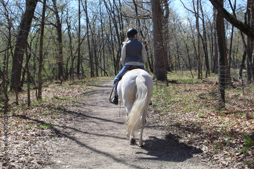 Woman riding a white horse in spring at Linne Woods in Morton Grove, Illinois © John
