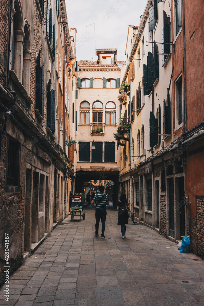 The italian street with beautiful buildings and people around. Film effect and author processing of photo.