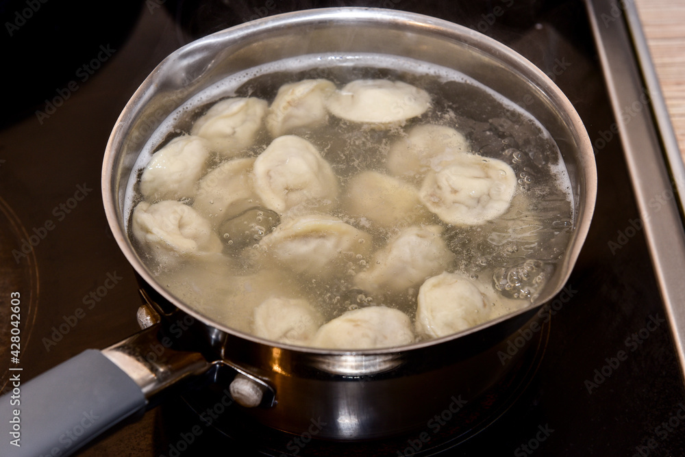 Russian Dumplings in boiling water. Meat dumplings are boiled in a pot of boiling water Russian Dumplings in boiling water. Meat dumplings are boiled in a pot of boiling water