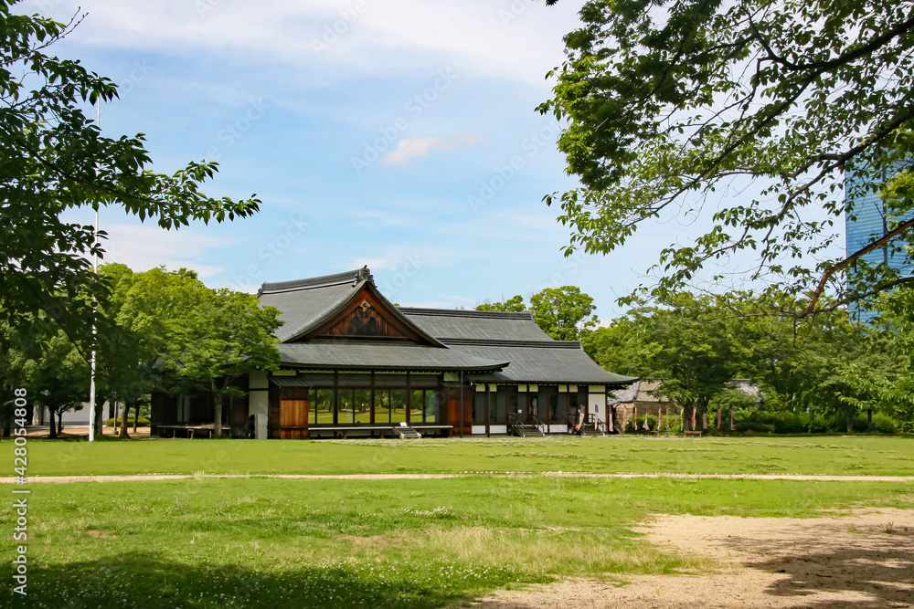 Obraz premium 大阪城西の丸庭園の緑の芝生と木造の和風建築