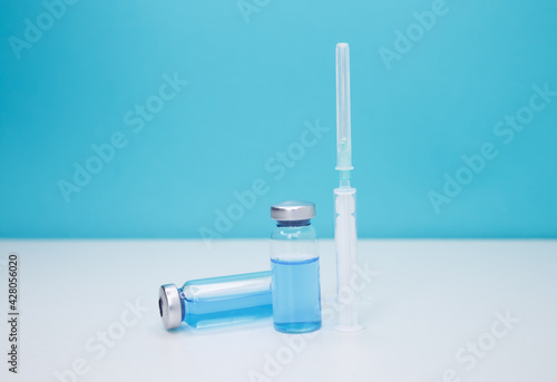 Covid-19 vaccination background. Coronavirus vaccine bottles and syringe injection. Medicine vials and syringe. Healthcare and medical concept. Doctor preparing the vaccine. A vaccine against disease.