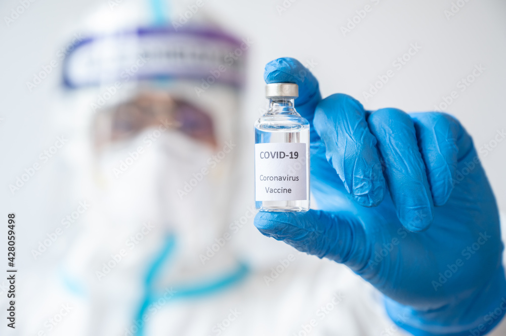 Close-up of medical worker holding a bottle of covid-19 vaccine. 