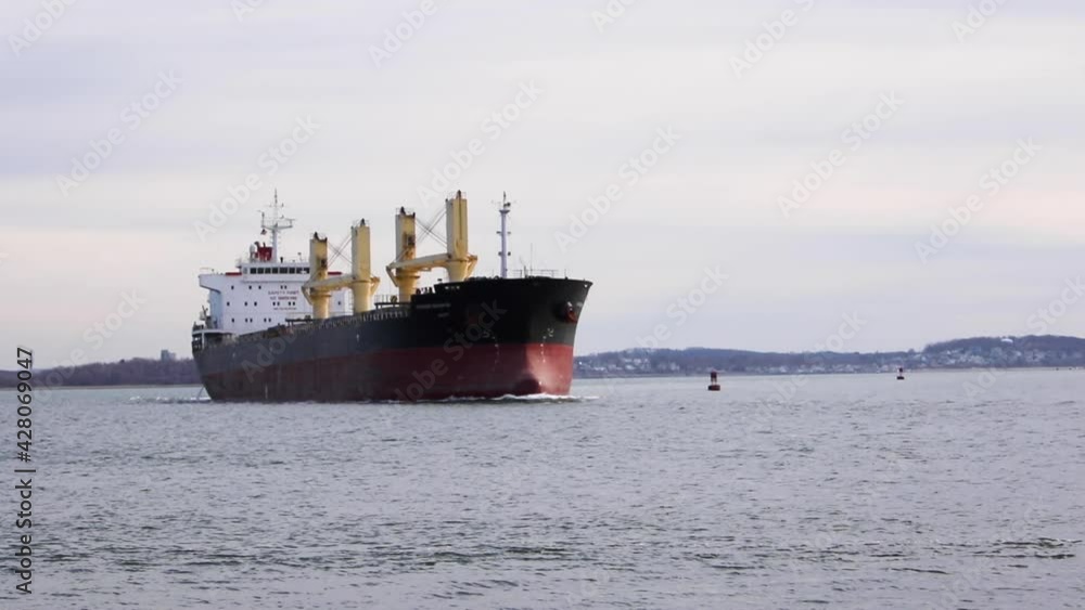 Very large Tanker making a turn across harbor, static tripod establishing Very large Tanker making a turn across harbor, static tripod establishing