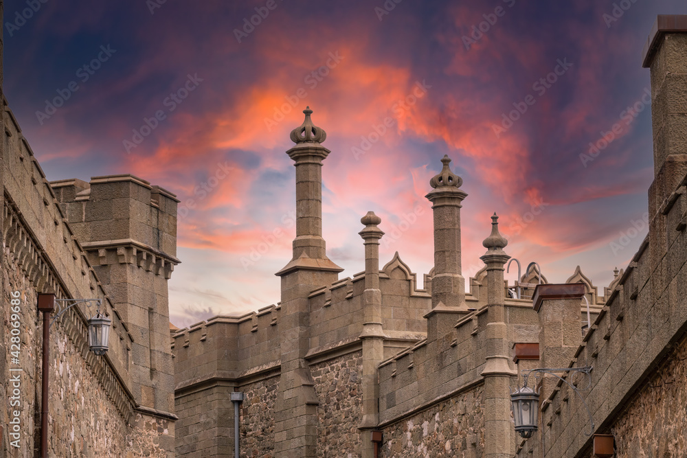 The walls and towers of the old palace on the background of beautiful pink sunset