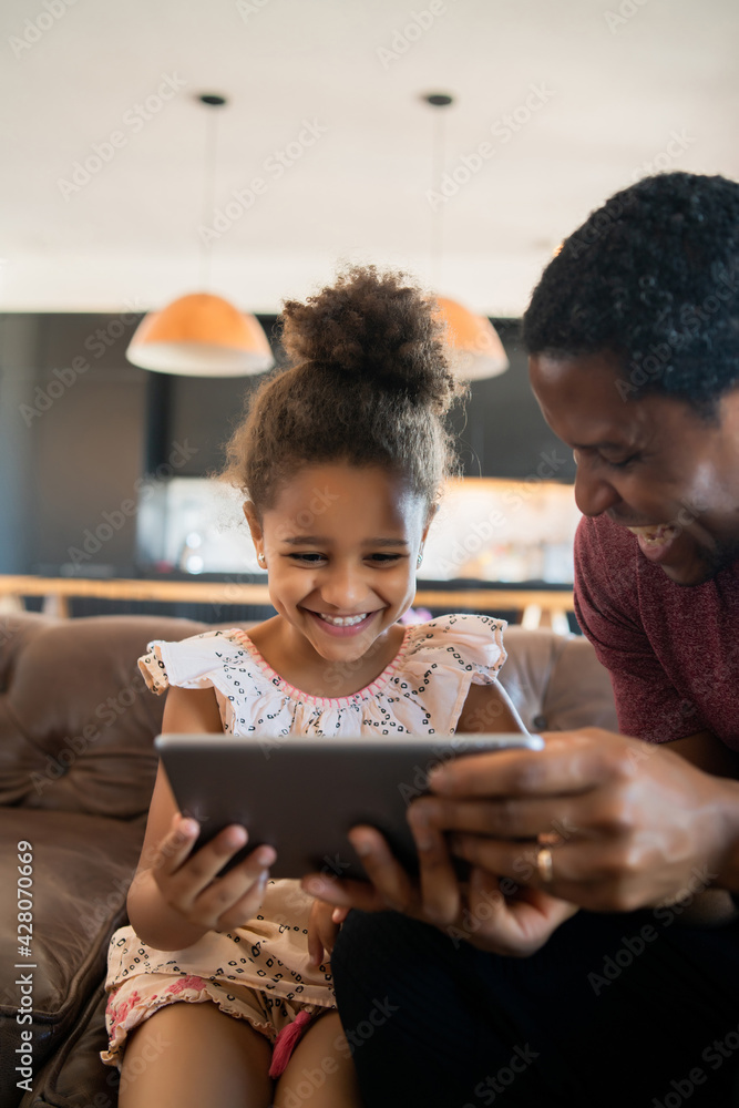 Father and daughter using digital tablet at home. Father and daughter using digital tablet at home.