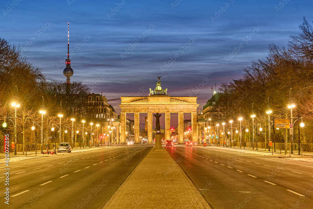 The famous Brandenburg Gate in Berlin with the Television Tower at dawn