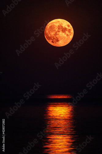 Super full blood moon and moon light over the sea