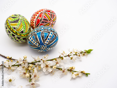 Closeup shot of beautifully painted easter eggs and flowers on a white surface