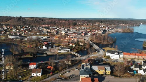 Slow aerial flight above beautiful swedish rural region during sunny day and blue sky. Blue lake and mountain hills in backdrop. Bengtsfors, Sweden. Picturesque landscape. photo