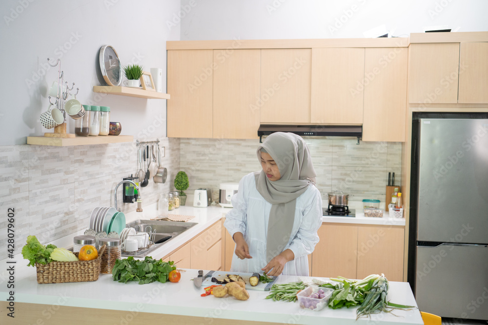 happy muslim woman preparing iftar dinner cooking in the kitchen alone happy muslim woman preparing iftar dinner cooking in the kitchen alone