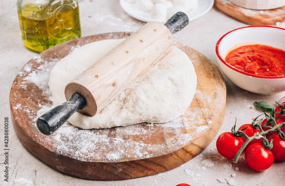 Fototapeta premium The ingredients for homemade Margherita pizza on stone background.