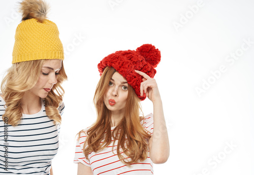 two women in multicolored hats hug friendship communication fashion cropped view