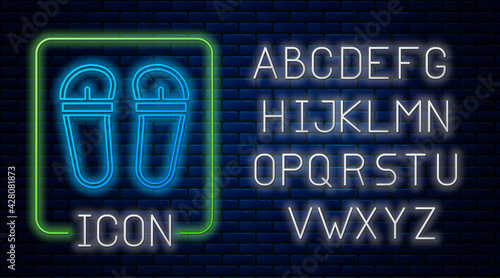 Glowing neon Flip flops icon isolated on brick wall background. Beach slippers sign. Neon light alphabet. Vector