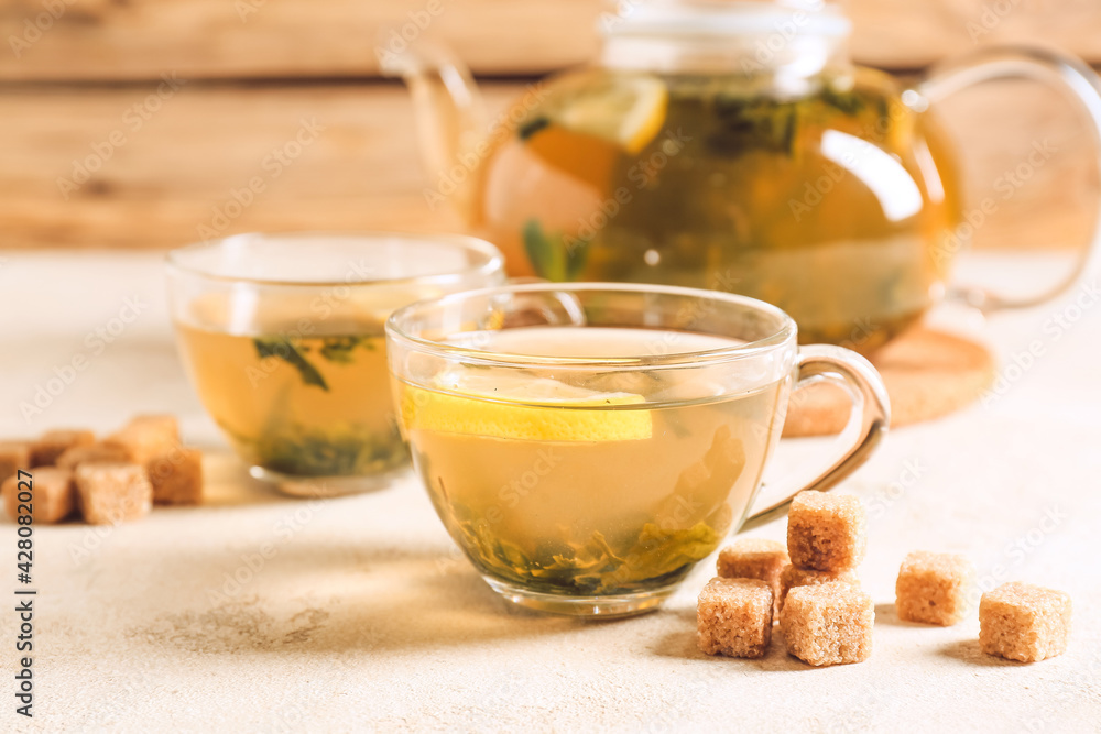 Teapot and cups of hot green tea on table Teapot and cups of hot green tea on table